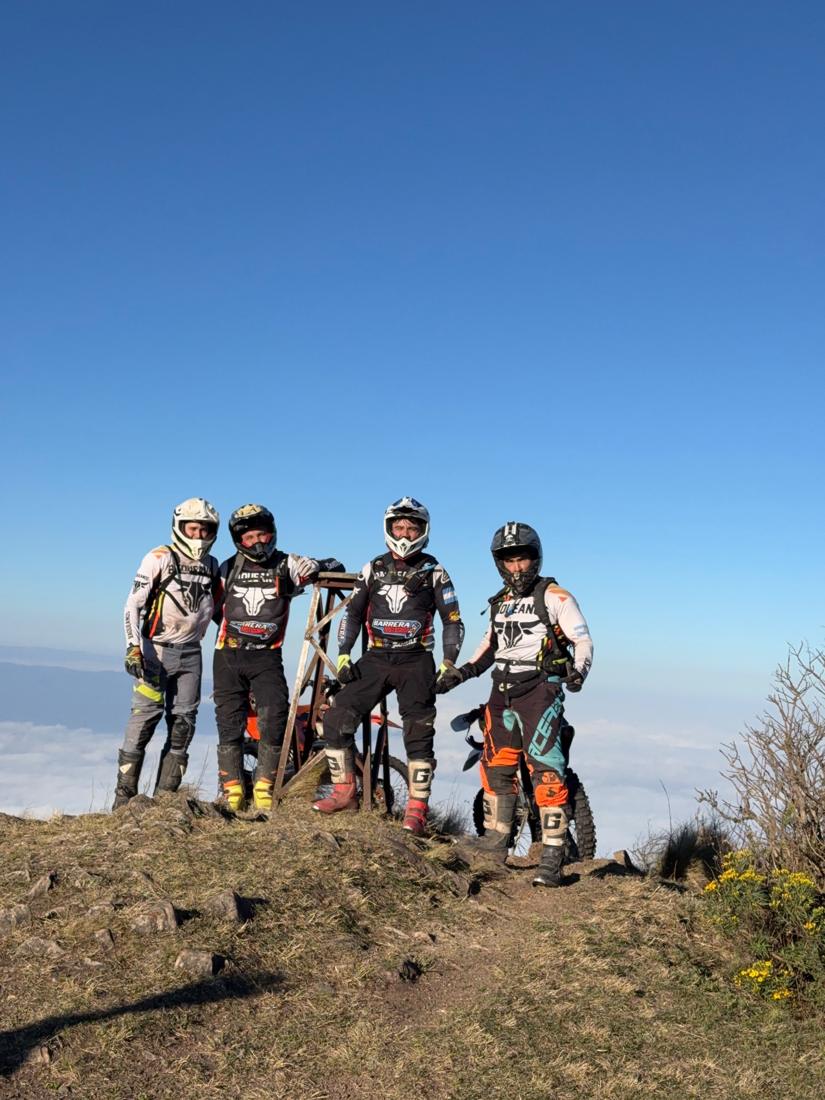 Cuatro pilotos en una cumbre sobre las nubes