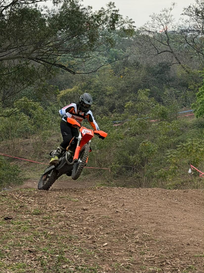 Piloto en moto naranja en el monte