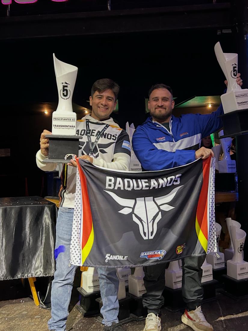 Dos pilotos con trofeo y bandera de BAQUEANOS